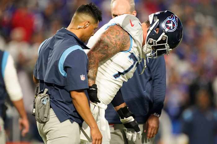 Tennessee Titans offensive tackle Taylor Lewan (77) is helped off the field during the first quarter against the Buffalo Bills at Highmark Stadium Monday, Sept. 19, 2022, in Orchard Park, New York.